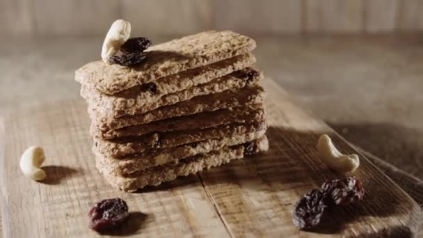 Biscoitos de aveia de grão inteiro, biscoitos crackers com nozes e passas, fundo de madeira horisontal, foco suave — Vídeo de Stock