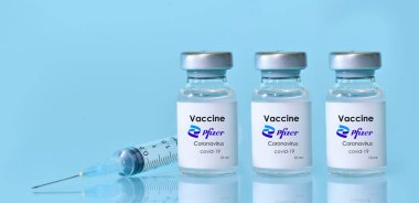 Harkiv. Ukrayna. 9 Ocak 2021. Şırınga, üzerinde Pfizer logosu olan üç şişe Coronavirus aşısı. Tıp, sağlık, bilim konsepti. Üç doz. Metin için alan kopyala.