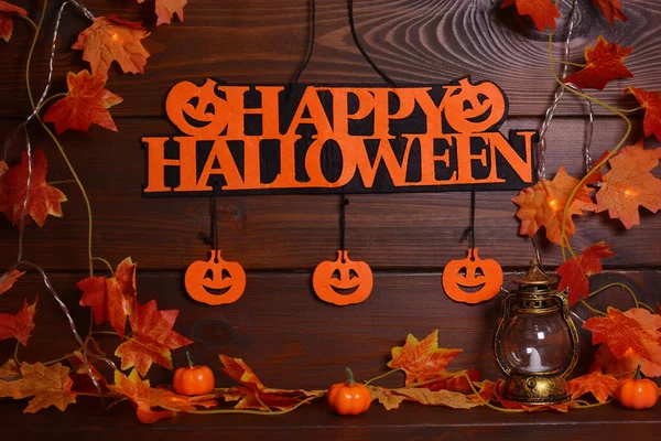 Balkabakları, yapraklar, çelenkler, ahşap arka planda Mutlu Cadılar Bayramı metinleri