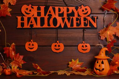 Balkabakları, yapraklar, çelenkler, ahşap arka planda Mutlu Cadılar Bayramı metinleri