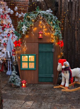 Tahta çocuklar Noel evi, at, Noel ağacı, cüce, açık hava. Çocuklar ve aileler için harika bir Noel fotoğrafı..