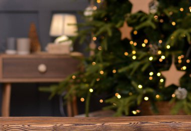 Noel arkaplanı. Noel ağacının arka planındaki boş ahşap masa ve yılbaşı pastası. Ürün montajı için hazır. Pankart