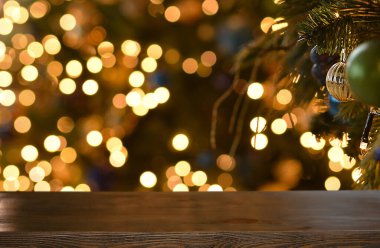 Noel arkaplanı. Noel ağacının arka planında boş ahşap masa ve yeni yılın altın çadırı. Ürün montajı için hazır. Boşluğu kopyala