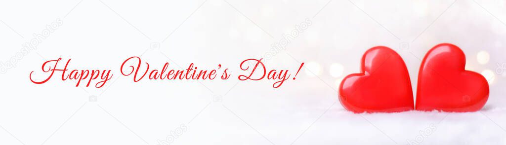 Two red hearts on a white background with bokeh. Postcard for Valentine's Day.Banner.Happy Valentine's Day