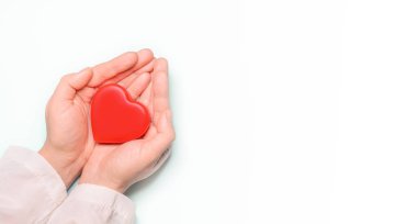 Doktor 'un elindeki kırmızı kalp beyaz arka planda. Sağlık ve hastane sağlık konsepti, organ bağışı konsepti. Sevgililer Günü 'nün sembolü. Kalp günü. ? opy boşluk.