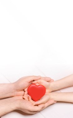 Kırmızı kalbi çocuğa çift olarak veren bir adam. Sağlık ve hastane tıbbi konsepti. Bağış konsepti. Sevgililer Günü 'nün sembolü. Üst görünümü, yazı için alan. ? opy boşluk.