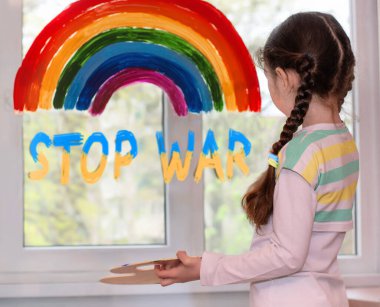 Kız pencereye bir gökkuşağı çiziyor ve 