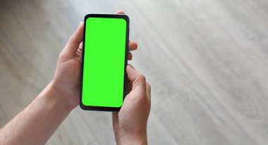 Adamın biri elinde yeşil ekranlı akıllı telefon tutuyor. Mockup.Mockup. Metin için alanı kopyala