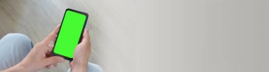 Adamın biri elinde yeşil ekranlı akıllı telefon tutuyor. Mockup.Mockup. Uzayı metin için kopyala. Pankart
