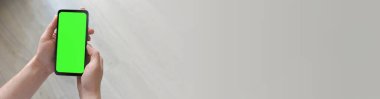 Adamın biri elinde yeşil ekranlı akıllı telefon tutuyor. Mockup.Mockup. Uzayı metin için kopyala. Pankart