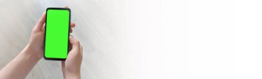 Adamın biri elinde yeşil ekranlı akıllı telefon tutuyor. Mockup.Mockup. Uzayı metin için kopyala. Pankart