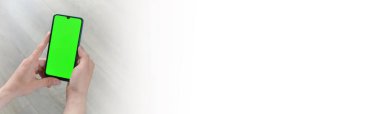 Adamın biri elinde yeşil ekranlı akıllı telefon tutuyor. Mockup.Mockup. Uzayı metin için kopyala. Pankart