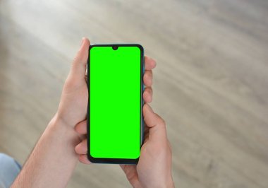 Adamın biri elinde yeşil ekranlı akıllı telefon tutuyor. Mockup.Mockup. Metin için alanı kopyala
