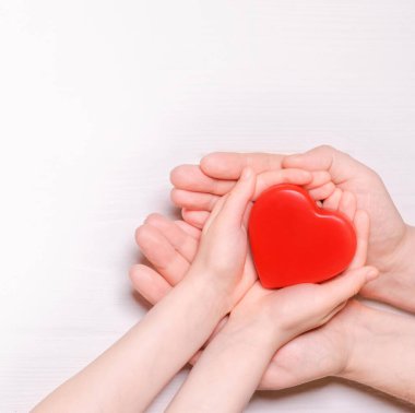 Kırmızı kalbi çocuğa çift olarak veren bir adam. Sağlık ve hastane tıbbi konsepti. Bağış konsepti. Sevgililer Günü 'nün sembolü. Metin için alanı olan üst görünüm..