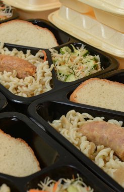 Beslenme çantaları (salata, tavuk budu, makarna). Muhtaç ve içten dışlanmış insanlar için bedava öğle yemekleri. Yemek teslimatı konsepti. Çevrimiçi emirler