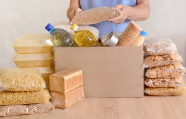 Gönüllüler bağış kutusuna yiyecek topluyor. Makarna, yağ, konserve yiyecek, konsantre süt, kurabiye, şeker, ihtiyaç sahipleri için akşam yemeği. Gönüllüler mülteciler için bağış topluyor. Yardım Fonları, Bağışlar.