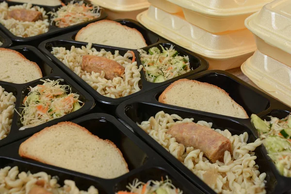 Lunch boxes (salad, chicken leg, pasta). Free lunches for needy and internally displaced persons. Lunch delivery concept. Online orders