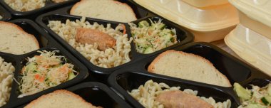 Beslenme çantaları (salata, tavuk budu, makarna). Muhtaç ve içten dışlanmış insanlar için bedava öğle yemekleri. Yemek teslimatı konsepti. Çevrimiçi emirler