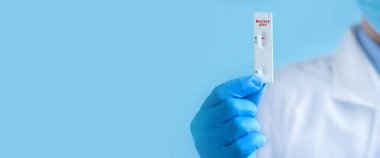 Koruyucu maske ve eldiven takan bir doktor veya hemşire, yeni koronavirüsün IgM ve IgG antikorlarını tespit etmek için hızlı bir Maymun Çiçeği Virüsü (MPXV) testi gösteriyor. Olumsuz sonuç