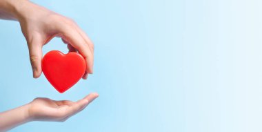 El sanatları uzmanı mavi arka plandaki başka birine kalp veriyor. Poster, afiş, metin için kopyalama alanı.