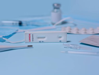Express Langya henipavirus (LayV) test,Schnelltest, medical mask, syringe,medicine on a blue background. Infected people suffer from fever, cough, headache, nausea and vomiting