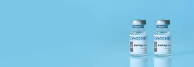 Two vials with vaccine Monkeypox on a blue background.The concept of medicine, healthcare. Monkeypox is a viral zoonotic disease. Monkeys may harbor the virus and infect people. Banner