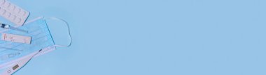 Express negative Monkeypox virus (MPXV) test, Schnelltest, medical mask, syringe,medicine on a blue background.The virus is transmitted from animals to humans.Banner.Copy space.
