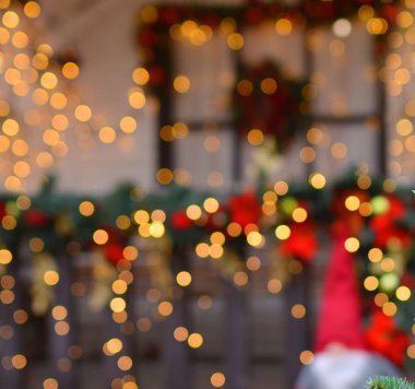 Beautiful blurred Christmas background with red gold bokeh on the background of the Christmas porch with a window and dwarfs