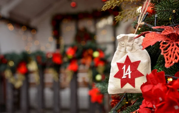 Christmas background. Advent calendar in the form of an eco bags hangs on the background of a Christmas porch.Christmas gifts and tasks