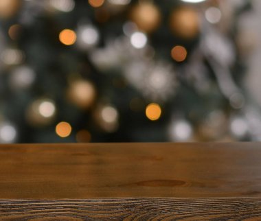 Noel arkaplanı. Noel ağacının arka planındaki boş ahşap masa ve yılbaşı pastası. Ürün montajı için hazır. Mutlu Noeller ve mutlu yıllar! Model