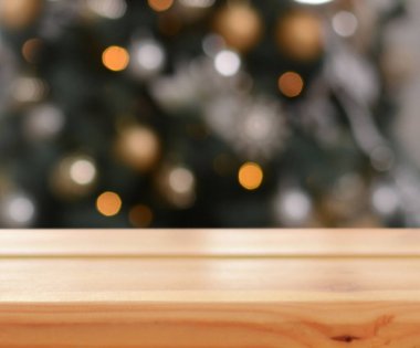 Noel arkaplanı. Noel ağacının arka planındaki boş ahşap masa ve yılbaşı pastası. Ürün montajı için hazır. Mutlu Noeller ve mutlu yıllar! Model