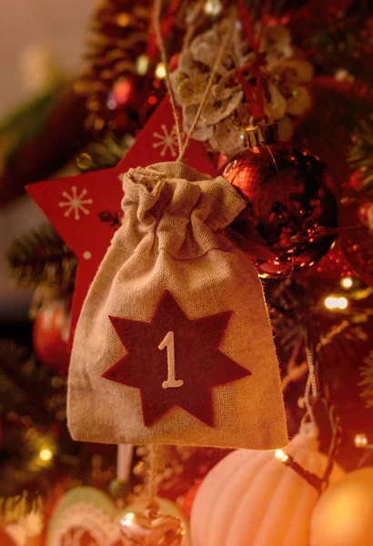 Christmas background. Advent calendar .Advent calendar in the form of an eco bag hangs on the Christmas tree.Vertical photo