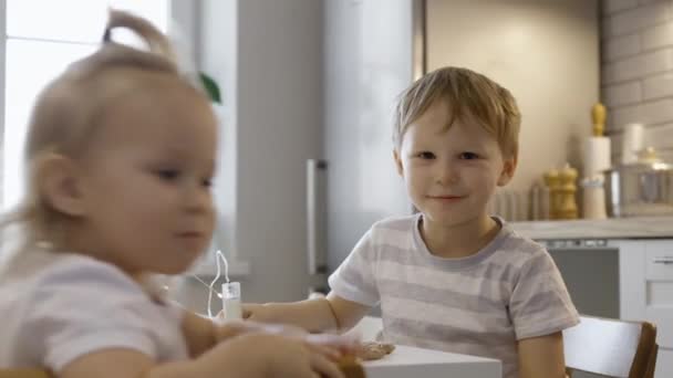 Barn Pratar När Sitter Vid Julbordet Pojke Och Flicka Dekorera — Stockvideo