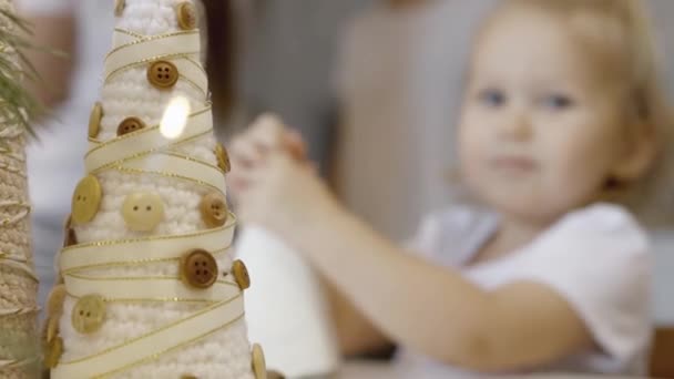 Een Schattig Klein Meisje Zit Aan Tafel Met Kerstversiering Tak — Stockvideo