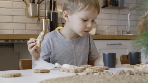 Kinderen Eten Kerstpeperkoek Keuken Een Jongen Een Meisje Schilderen Met — Stockvideo