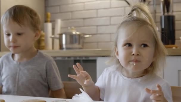 Dzieci Jedzą Pierniki Świąteczne Kuchni Chłopiec Dziewczynka Malują Kornetami Polewą — Wideo stockowe