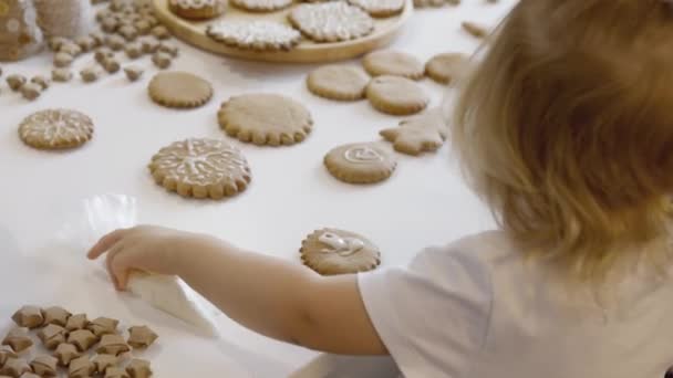 Χαριτωμένο Κορίτσι Διακοσμούν Και Τρώνε Χριστουγεννιάτικο Gingerbread Στο Σπίτι Ένα — Αρχείο Βίντεο