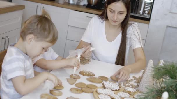 Mamma Och Barn Dekorerar Julpepparkakor Hemma Pojke Och Flicka Målar — Stockvideo