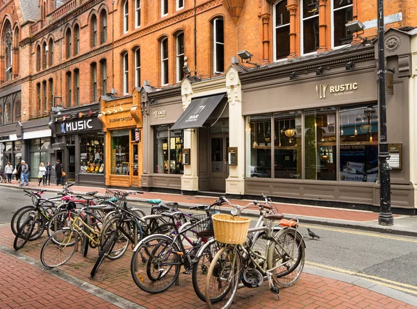 Dublin 'de alışveriş caddesi, önünde bir grup bisiklet ve arkasında dükkanlar olan bir bina..
