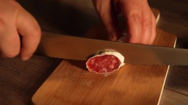 Tahta bir tahtanın üzerinde sosis keserken 10 saniyelik tam HD video klibi.