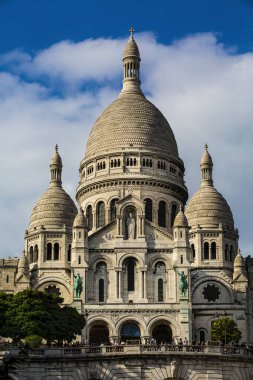 Montmartre 'nin Paris bölgesindeki Sacre-Coeur Bazilikası' nın önü güneşli bir günde gökyüzünde beyaz bulutlar.