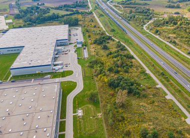 Malzeme deposunun havadan görüntüsü. Sanayi bölgesindeki lojistik dağıtım merkezi yukarıdan. Lojistik merkezde yüklenen kamyonların hava görüntüsü. İnsansız hava aracından görüntüle.