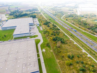 Malzeme deposunun havadan görüntüsü. Sanayi bölgesindeki lojistik dağıtım merkezi yukarıdan. Lojistik merkezde yüklenen kamyonların hava görüntüsü. İnsansız hava aracından görüntüle.