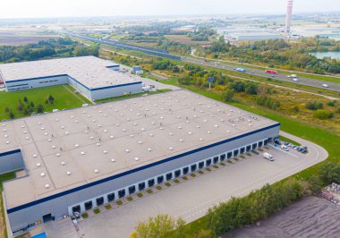 Malzeme deposunun havadan görüntüsü. Sanayi bölgesindeki lojistik dağıtım merkezi yukarıdan. Lojistik merkezde yüklenen kamyonların hava görüntüsü. İnsansız hava aracından görüntüle.