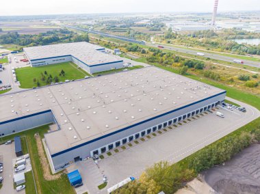 Malzeme deposunun havadan görüntüsü. Sanayi bölgesindeki lojistik merkezi yukarıdan. Lojistik merkezde yüklenen kamyonların hava görüntüsü. İnsansız hava aracından görüntüle.