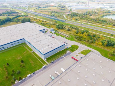 Malzeme deposunun havadan görüntüsü. Sanayi bölgesindeki lojistik merkezi yukarıdan. Lojistik merkezde yüklenen kamyonların hava görüntüsü. İnsansız hava aracından görüntüle.