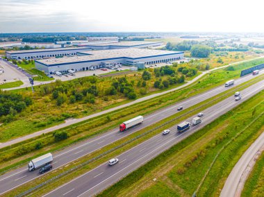 Malzeme deposunun havadan görüntüsü. Sanayi bölgesindeki lojistik merkezi yukarıdan. Lojistik merkezde yüklenen kamyonların hava görüntüsü. İnsansız hava aracından görüntüle.