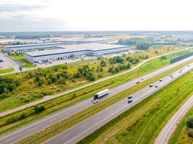 Malzeme deposunun havadan görüntüsü. Sanayi bölgesindeki lojistik merkezi yukarıdan. Lojistik merkezde yüklenen kamyonların hava görüntüsü. İnsansız hava aracından görüntüle.