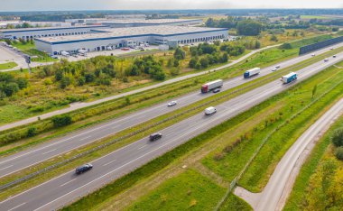 Malzeme deposunun havadan görüntüsü. Sanayi bölgesindeki lojistik merkezi yukarıdan. Lojistik merkezde yüklenen kamyonların hava görüntüsü. İnsansız hava aracından görüntüle.
