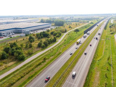 Malzeme deposunun havadan görüntüsü. Sanayi bölgesindeki lojistik merkezi yukarıdan. Lojistik merkezde yüklenen kamyonların hava görüntüsü. İnsansız hava aracından görüntüle.
